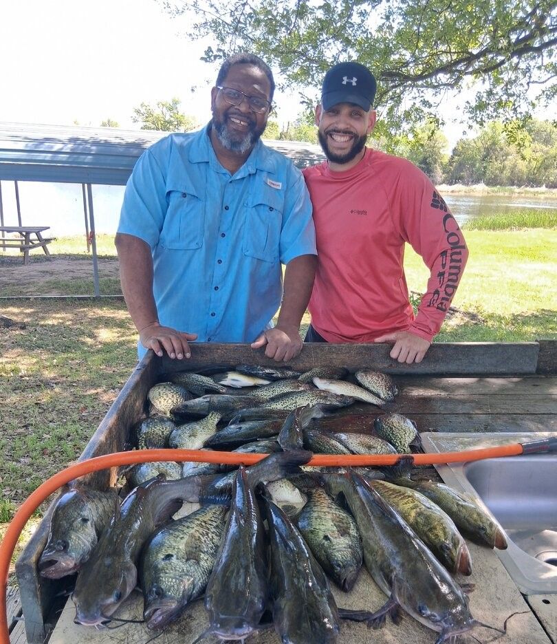 Large catch of freshwater fish displayed on cleaning table at outdoor fishing area