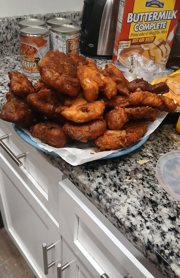 Fried chicken wings and drumsticks arranged on a plate in kitchen