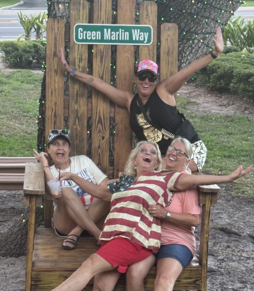 Outdoor recreational scene with wooden bench and street sign reading Green Marlin Way
