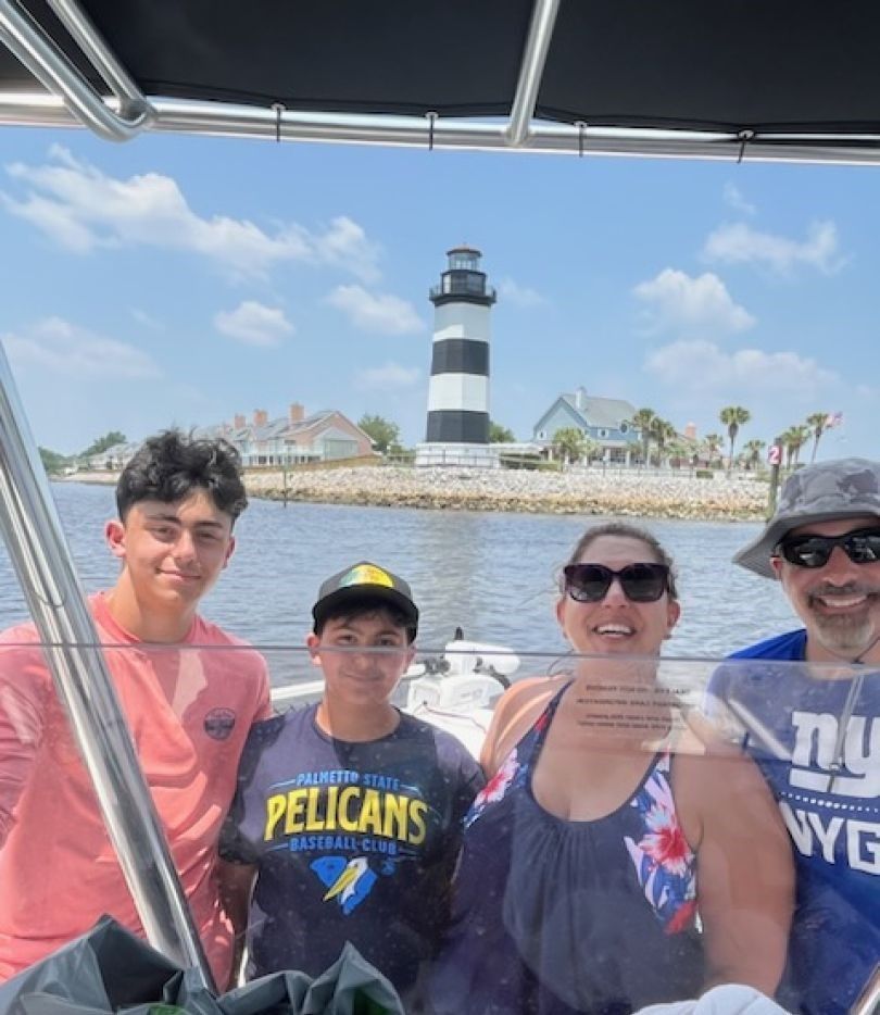 Boat trip with lighthouse visible in background on sunny day