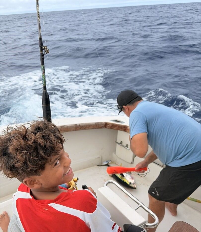 Fishing boat on ocean with fishing rods and equipment visible on deck