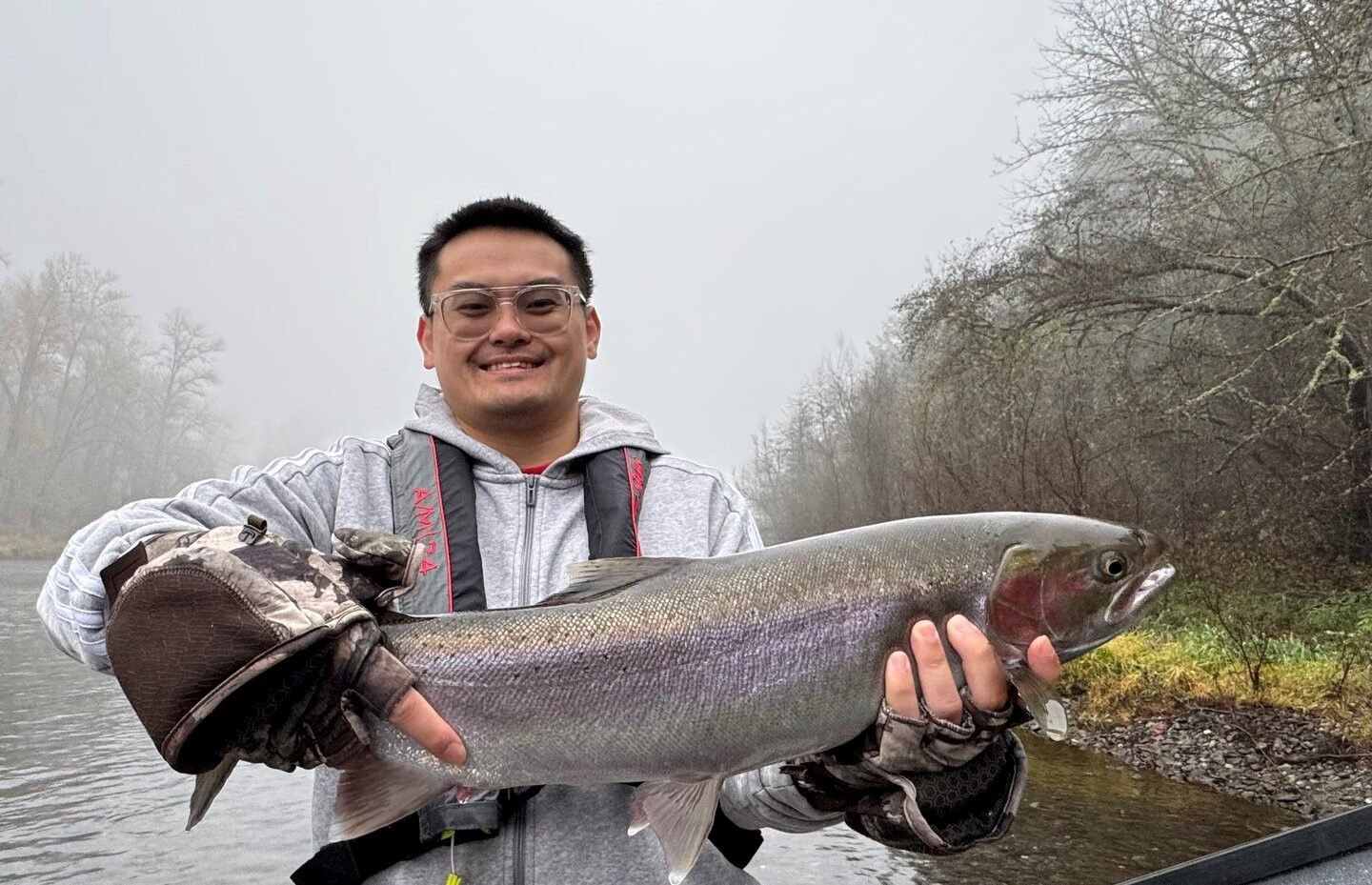 Large rainbow trout held up displaying successful fishing catch outdoors