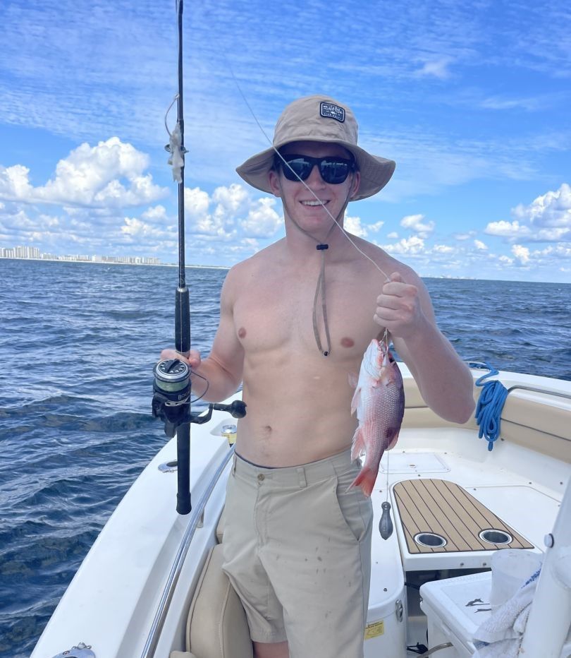 Freshly caught red snapper held up on fishing boat in ocean waters
