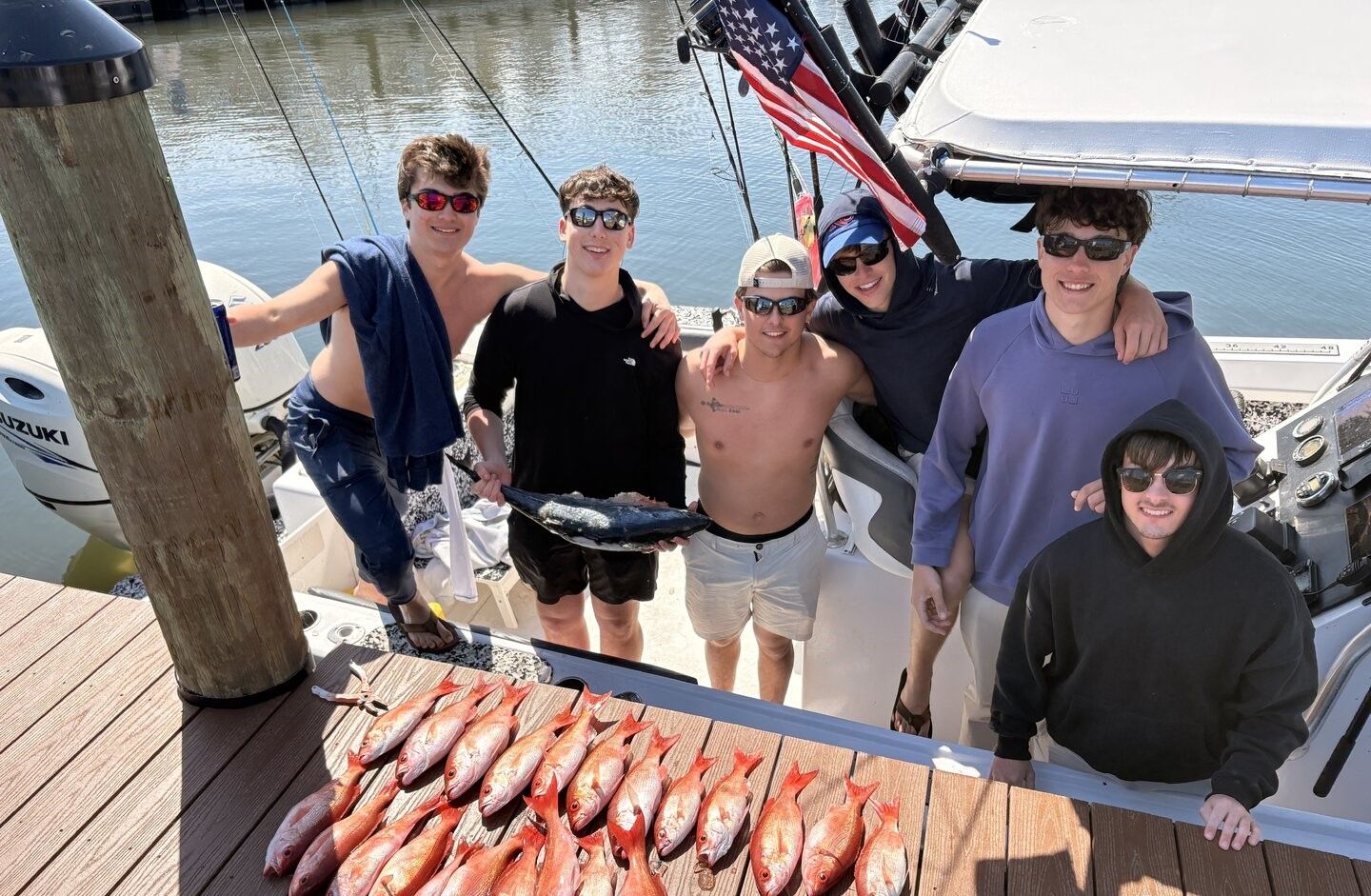 Fresh caught red snapper fish laid out on wooden dock after successful fishing trip