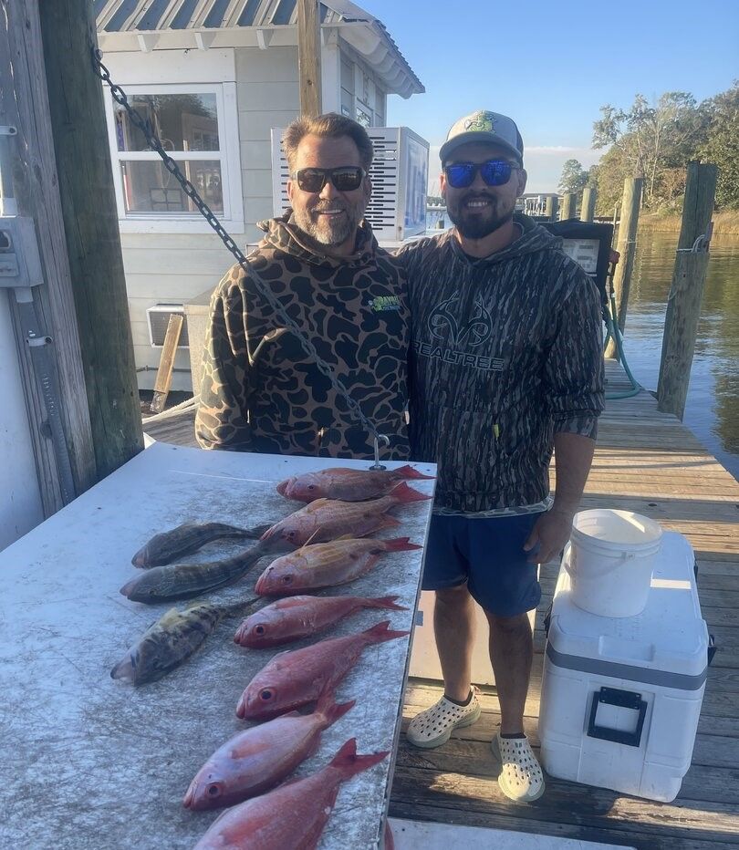 Fresh caught red snapper and other fish displayed on cleaning table at fishing dock