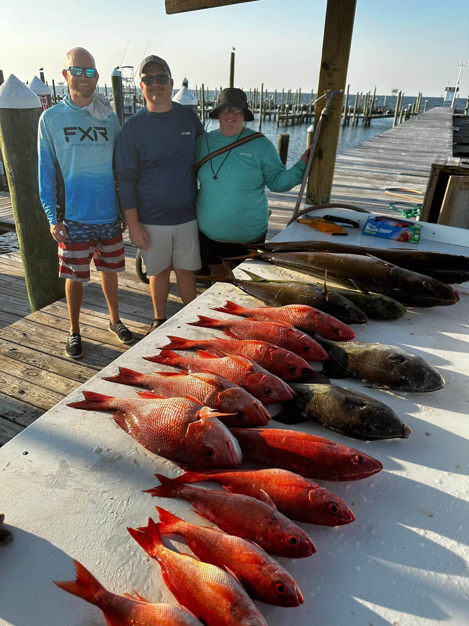 Fishing charter catch display showing red snapper and grey triggerfish laid out on boat deck at marina