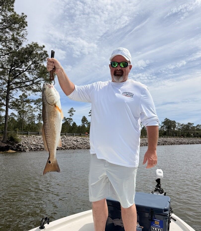 Angler holding freshly caught redfish on fishing boat