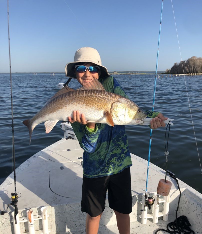 Angler holding large redfish on fishing boat