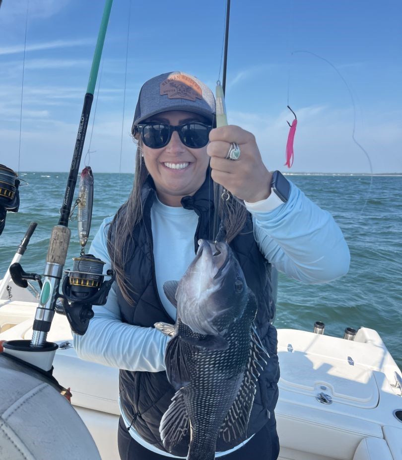 Angler catching a sea bass while fishing