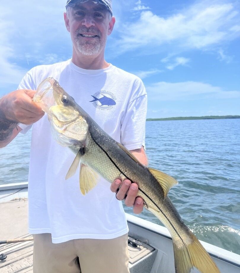 Angler holding freshly caught snook on fishing boat