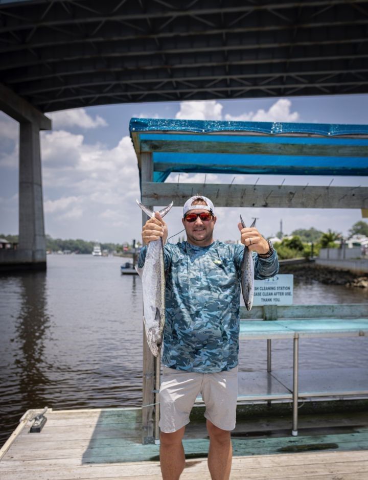 Two Spanish mackerel caught during offshore fishing trip displayed at marina dock