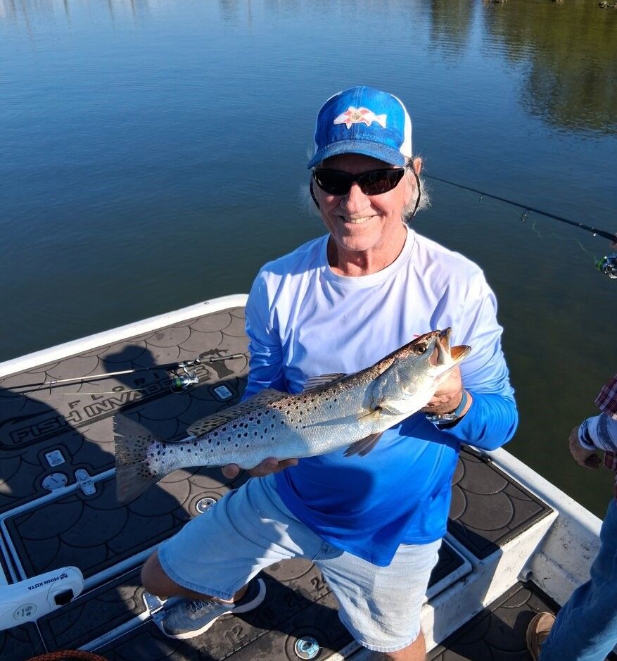 Angler holding speckled trout on fishing boat