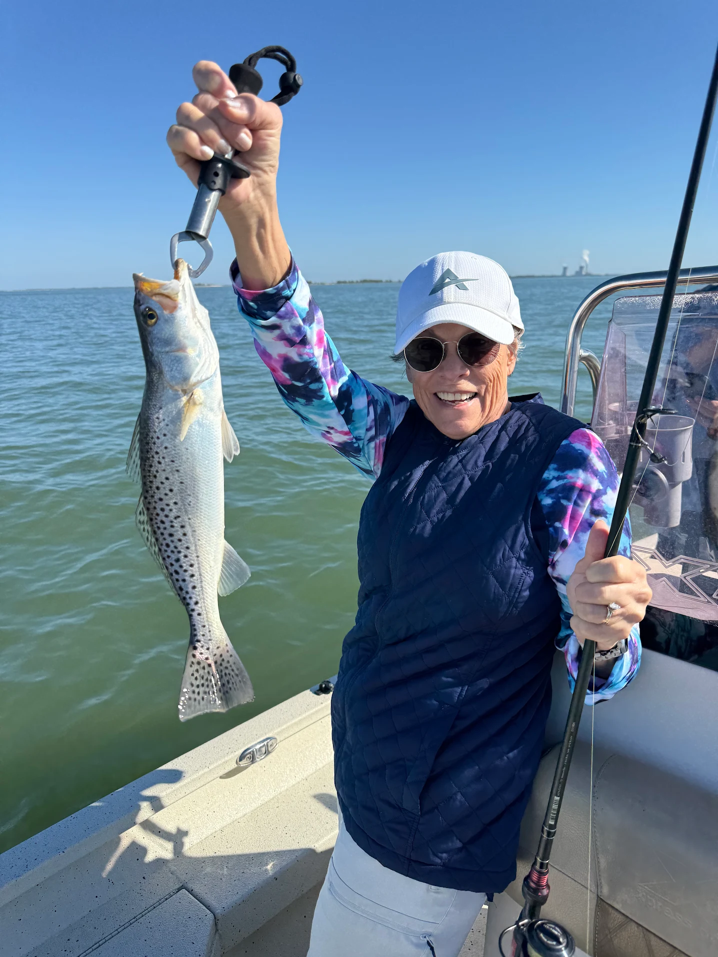 Angler holding freshly caught speckled trout on fishing boat