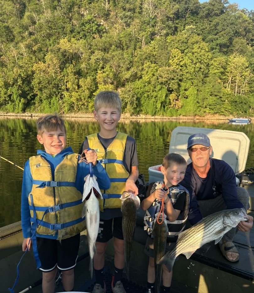 Successful fishing trip with multiple striped bass caught on calm lake water
