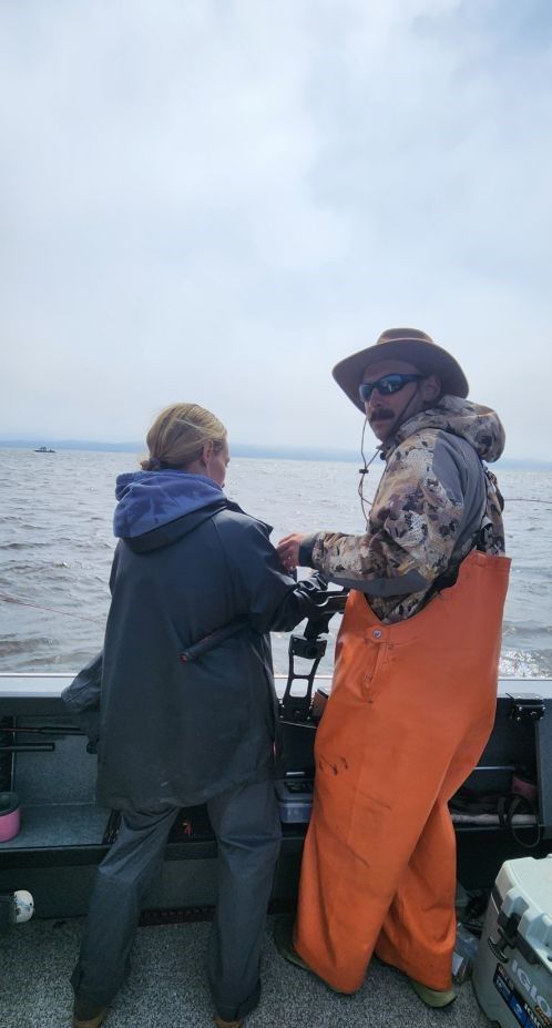 Two people fishing in an unknown location.
