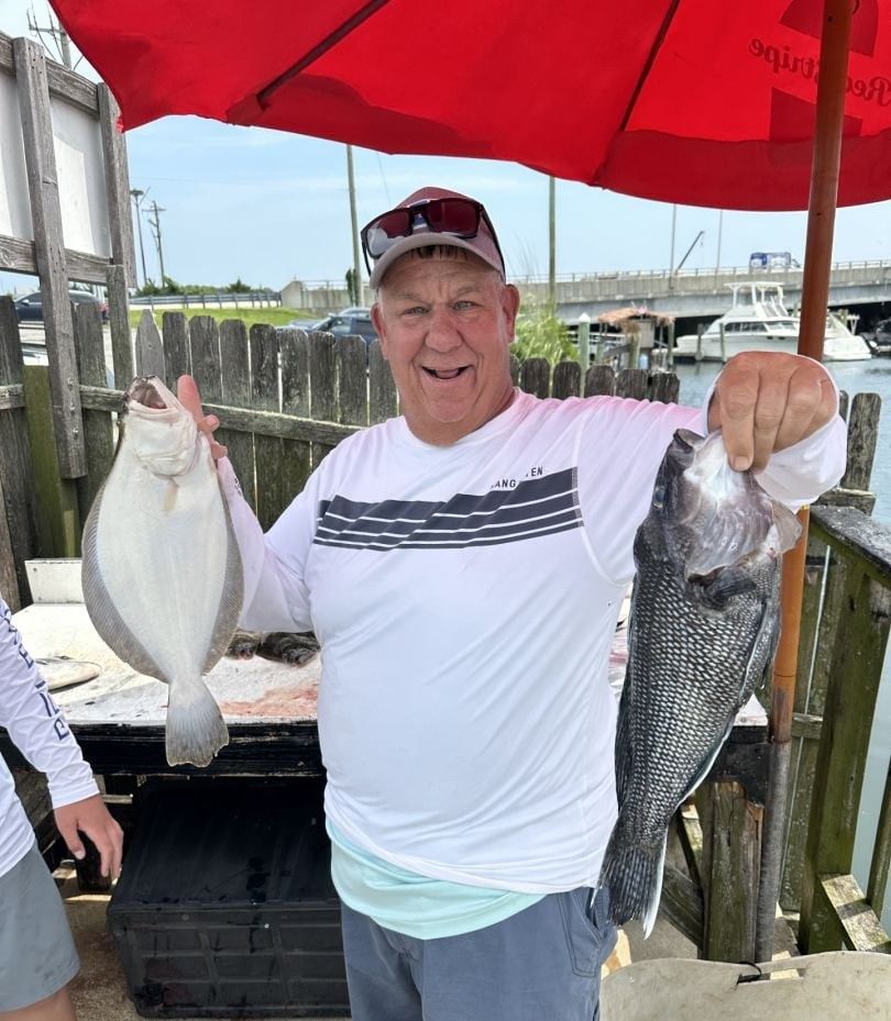 Person fishing with two fish in unknown location