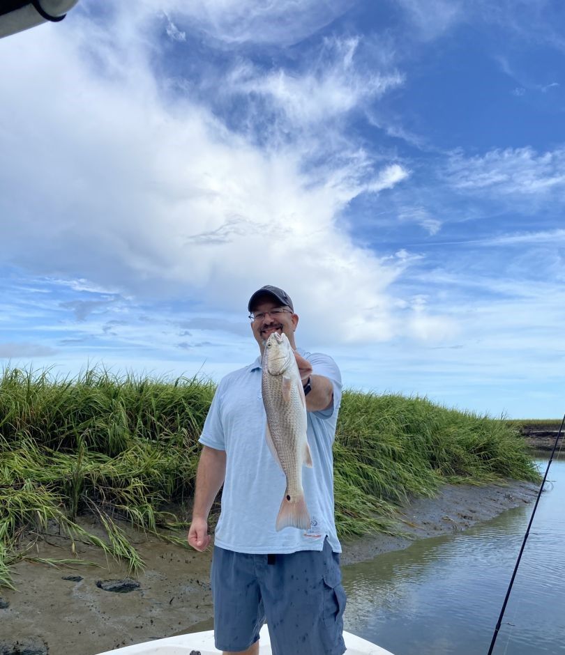 Fisherman holding big 22-inch catch in unknown location