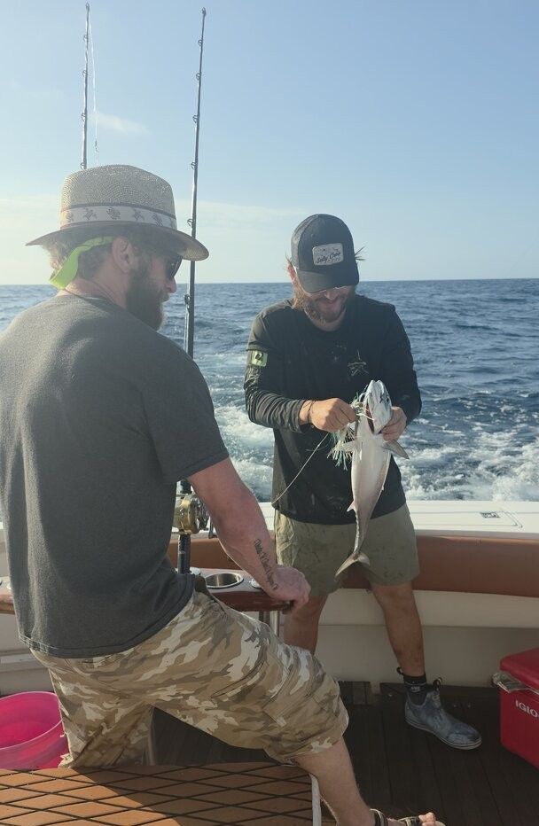 Fresh caught fish being held on fishing boat deck with ocean in background