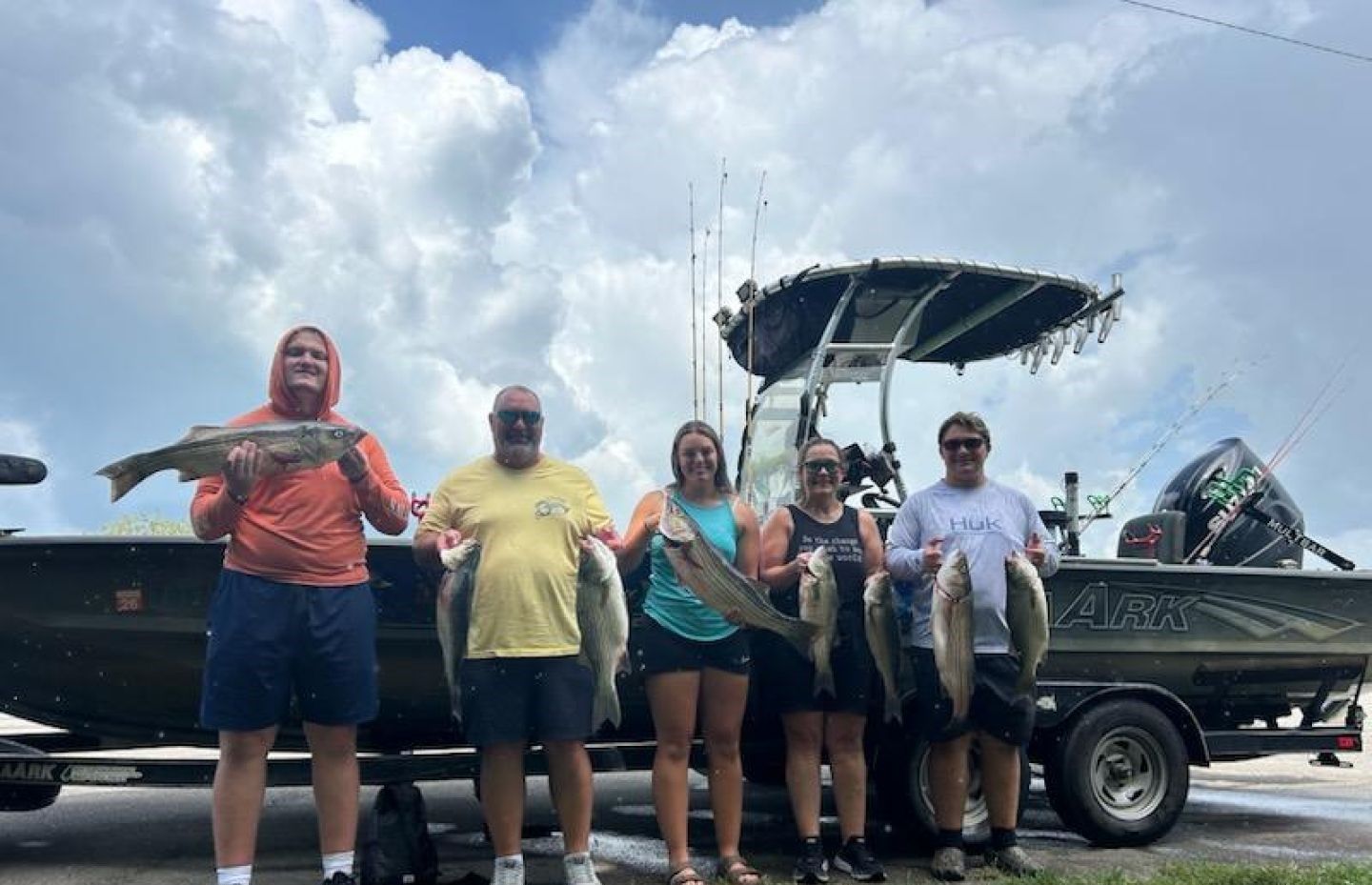 Fishing group displaying their catch of multiple fish species after successful fishing trip