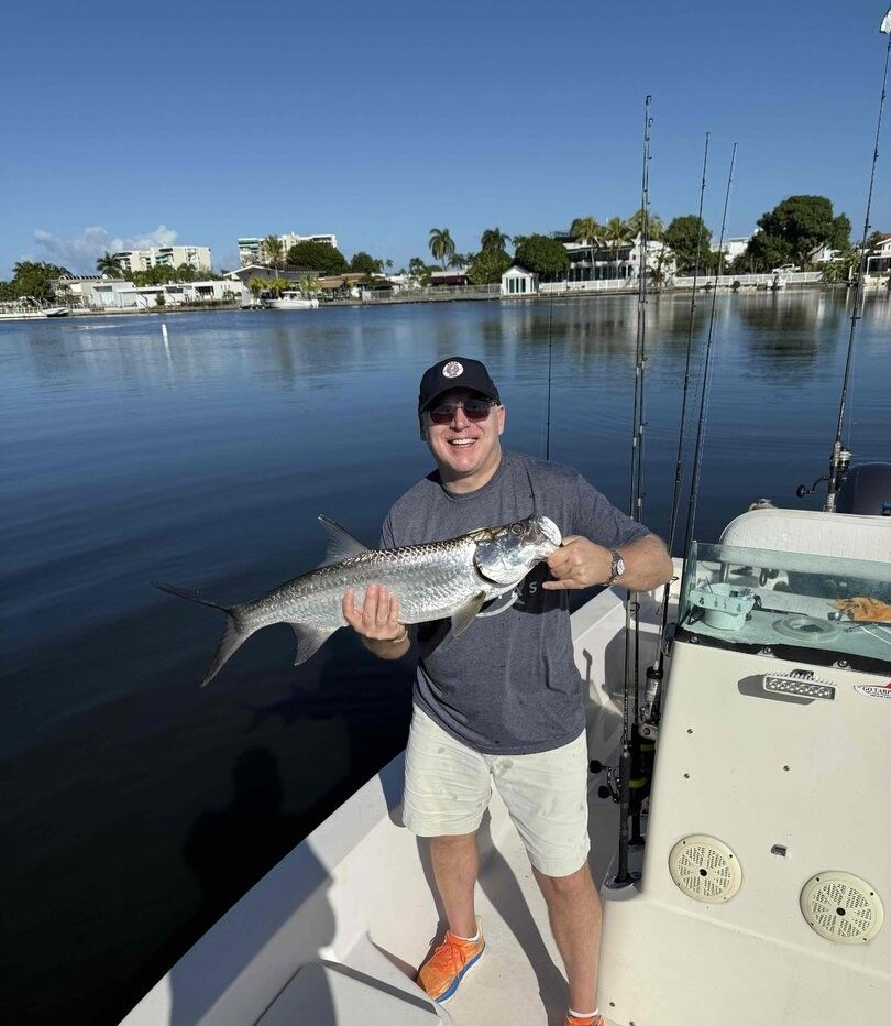 Angler holding freshly caught tarpon on fishing boat