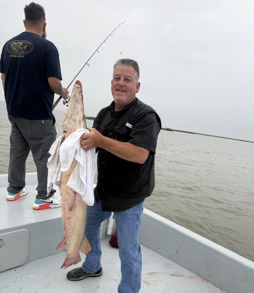 Large fish being displayed on fishing boat deck over water