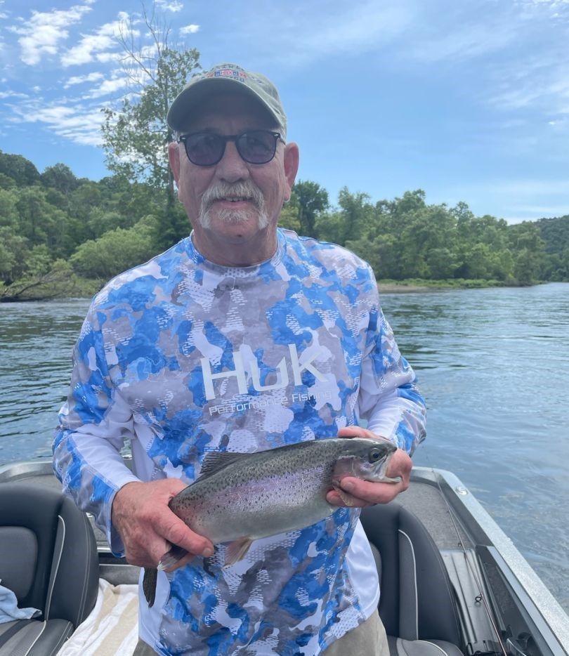 Angler fishing for a rainbow trout in an unknown location
