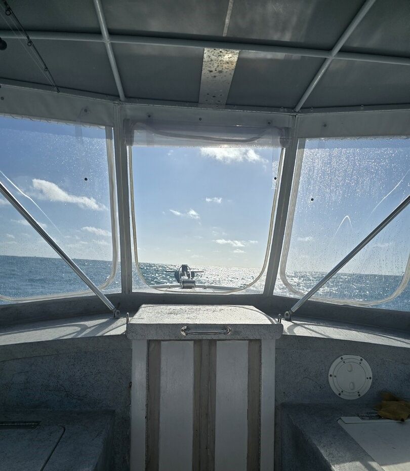 View from boat wheelhouse showing ocean horizon and another vessel in distance
