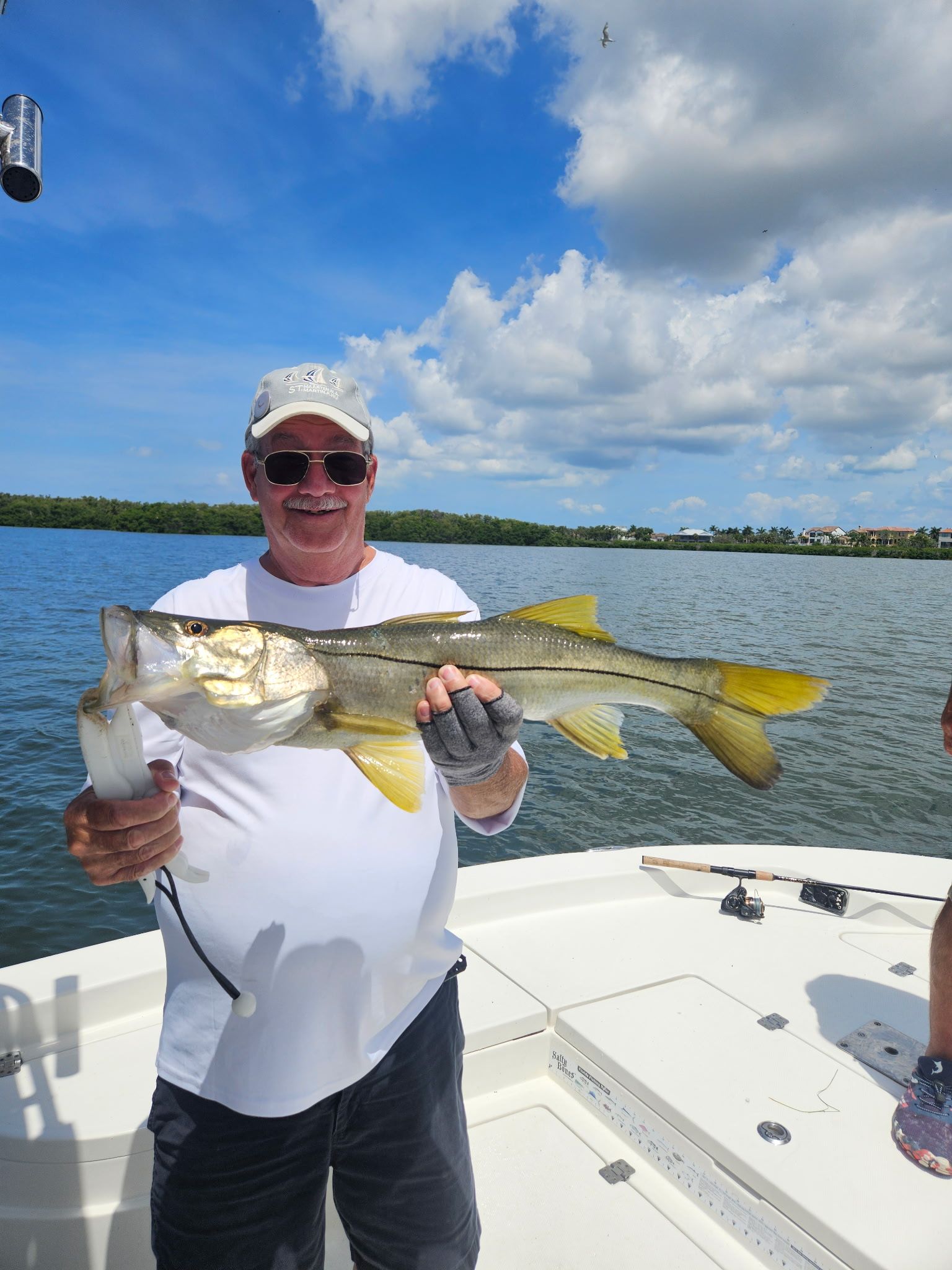 Angler holding freshly caught snook on fishing boat