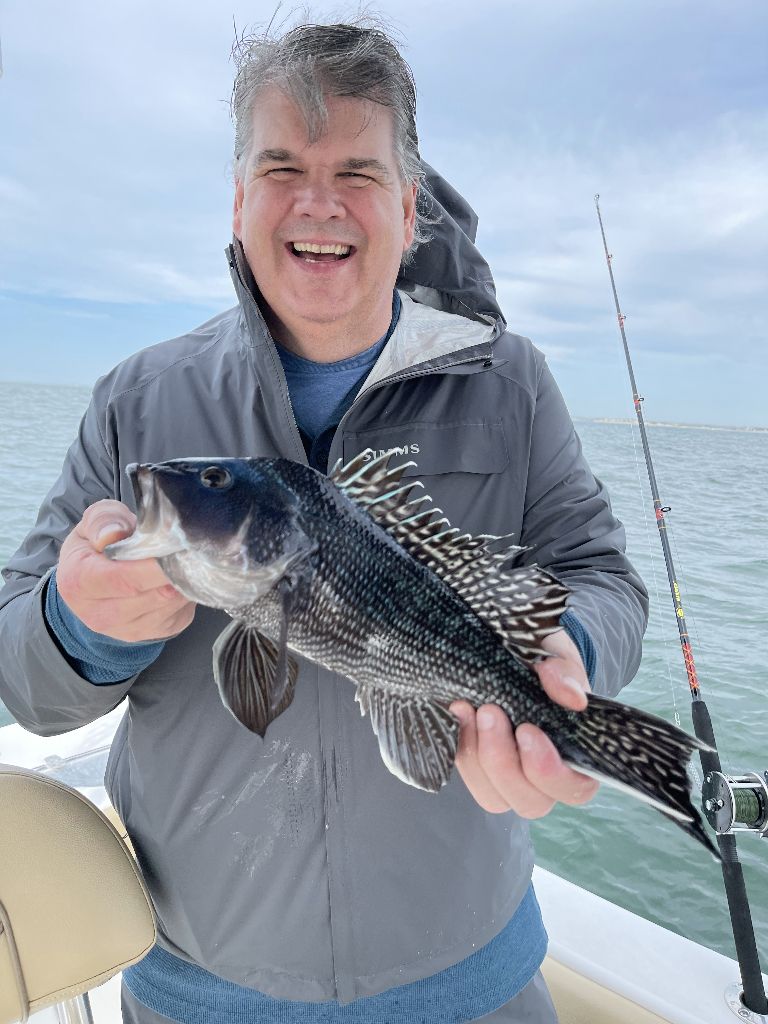 A lone fisherman casting into the water