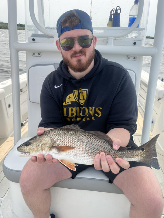 Reeling in a fiery red catch on a partly cloudy day with a chance of late rain