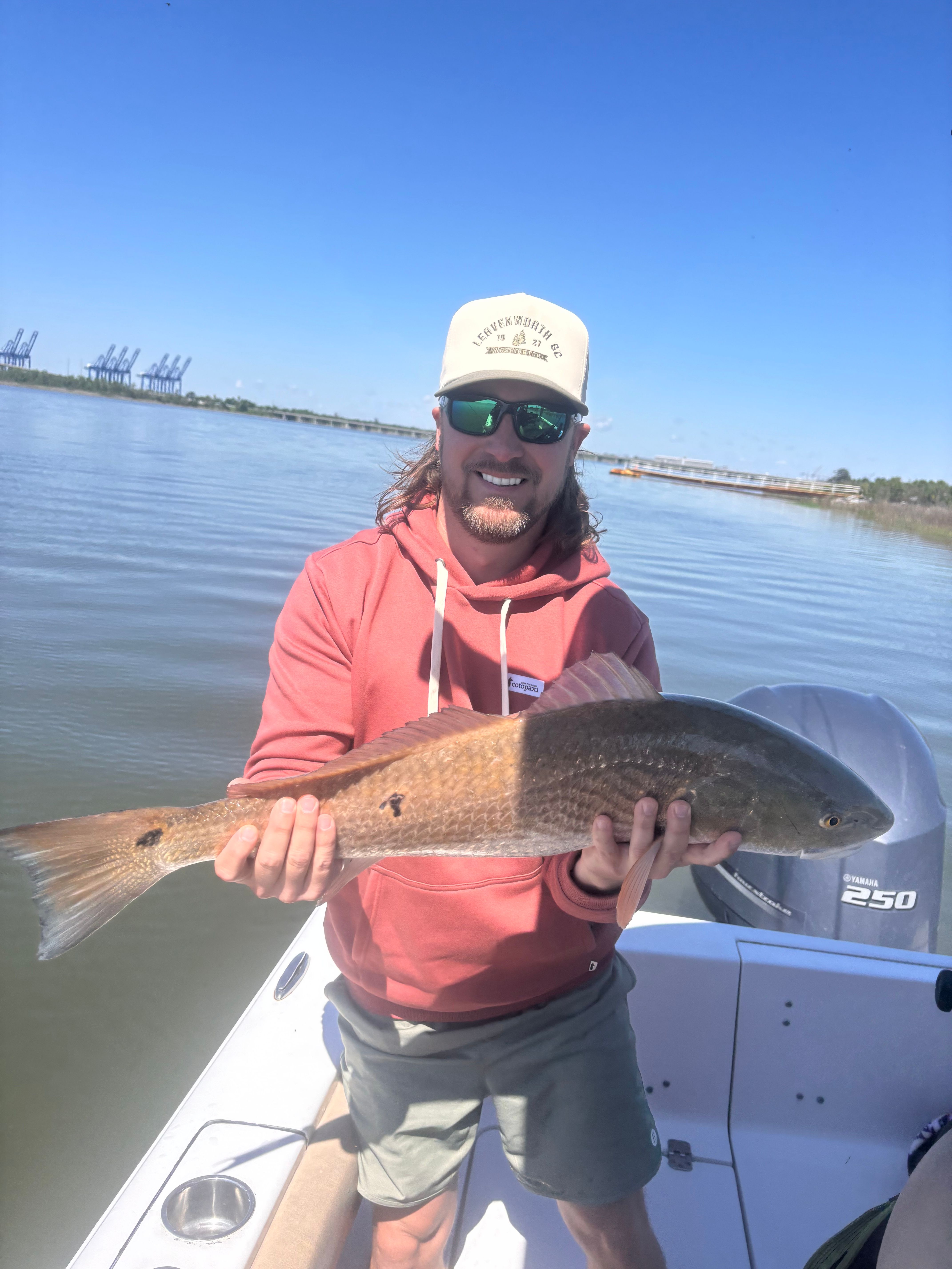 Angler holding freshly caught redfish on fishing boat
