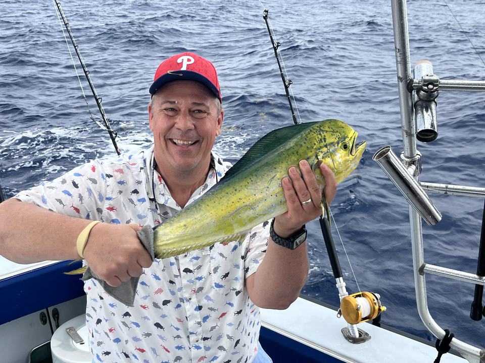 Reeling in a stunning Mahi Mahi under partly cloudy skies!