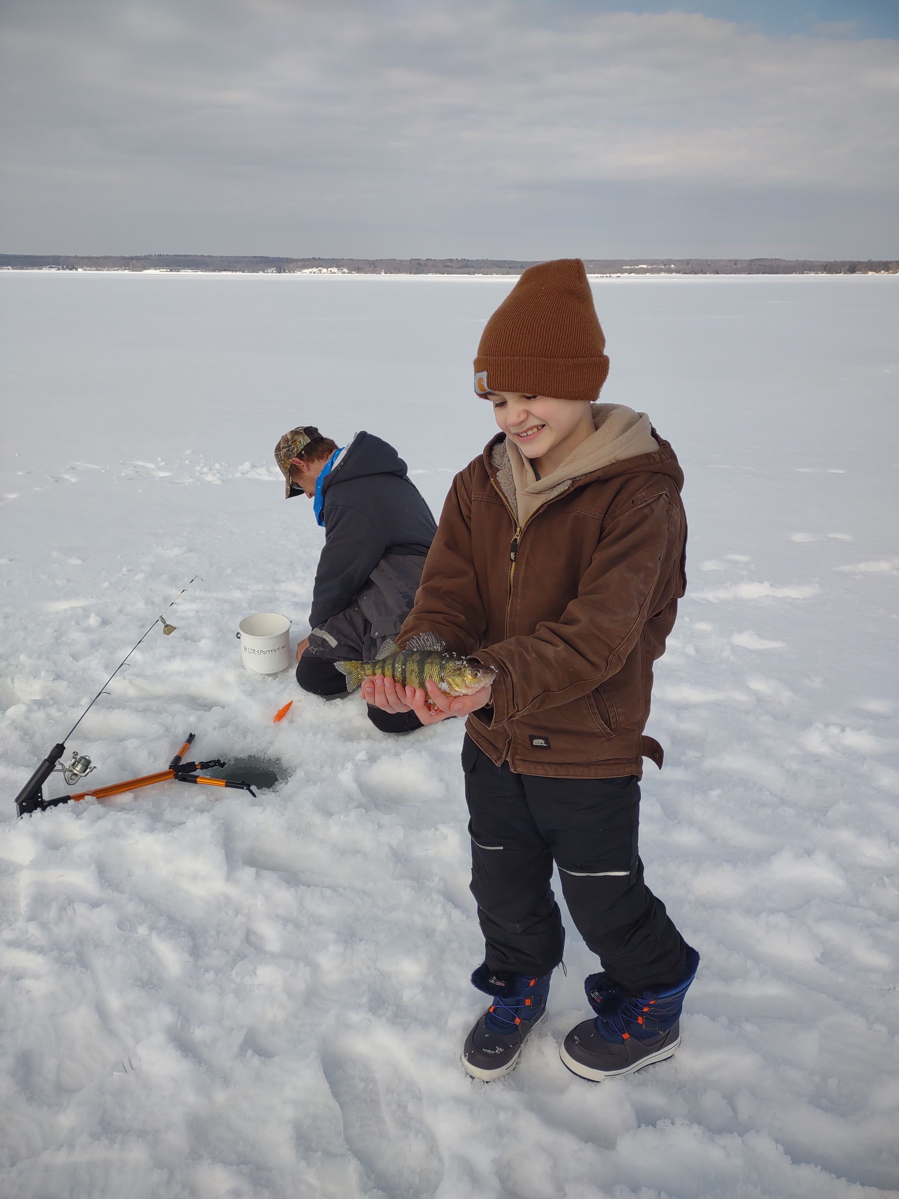 Ice fishing scene with caught American Yellow Perch and fishing equipment on frozen lake
