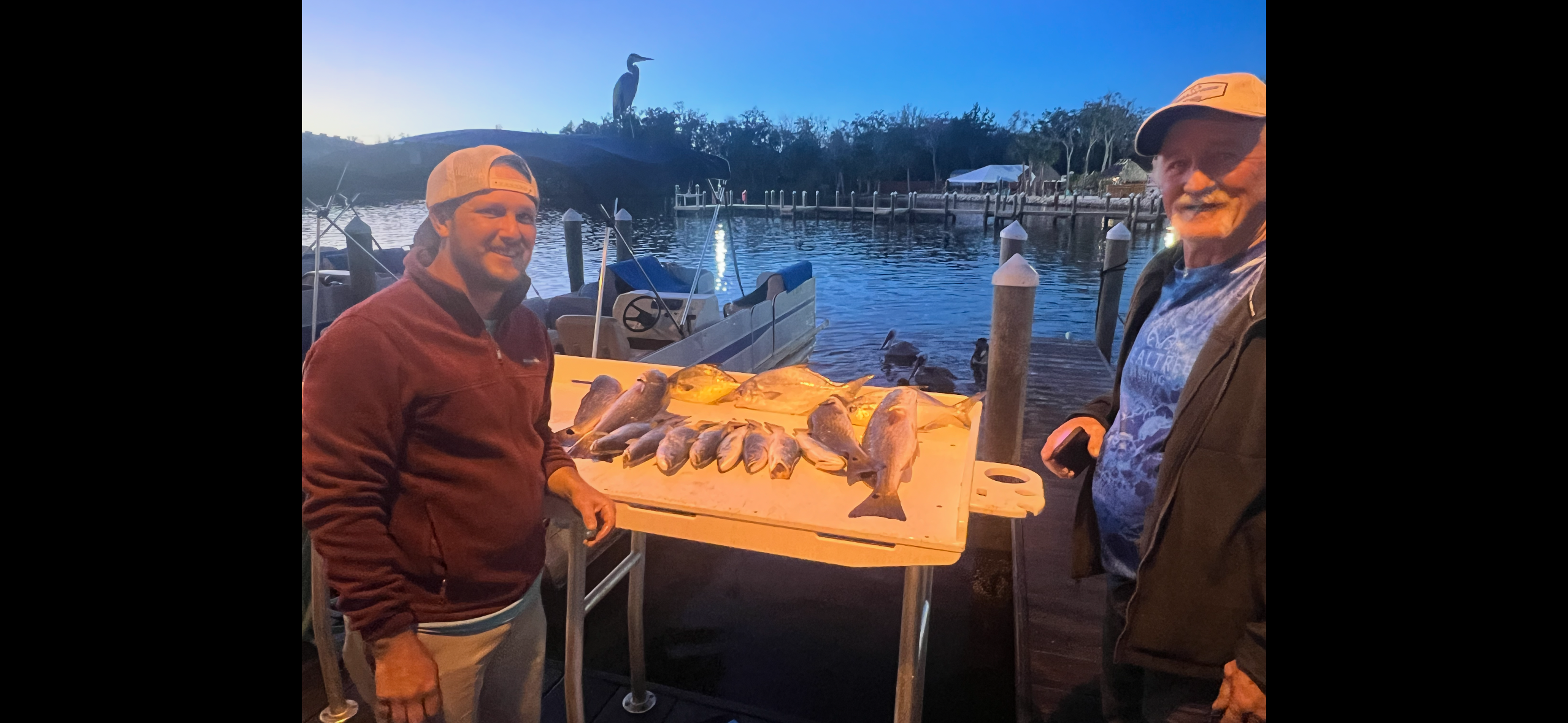 Two people fishing at a scenic location