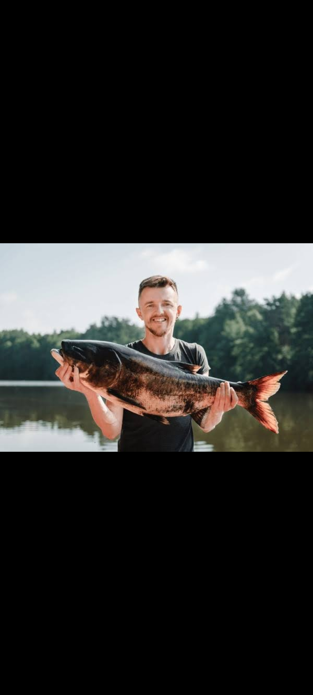Angler with a big 28-inch fish, fishing in an unknown location