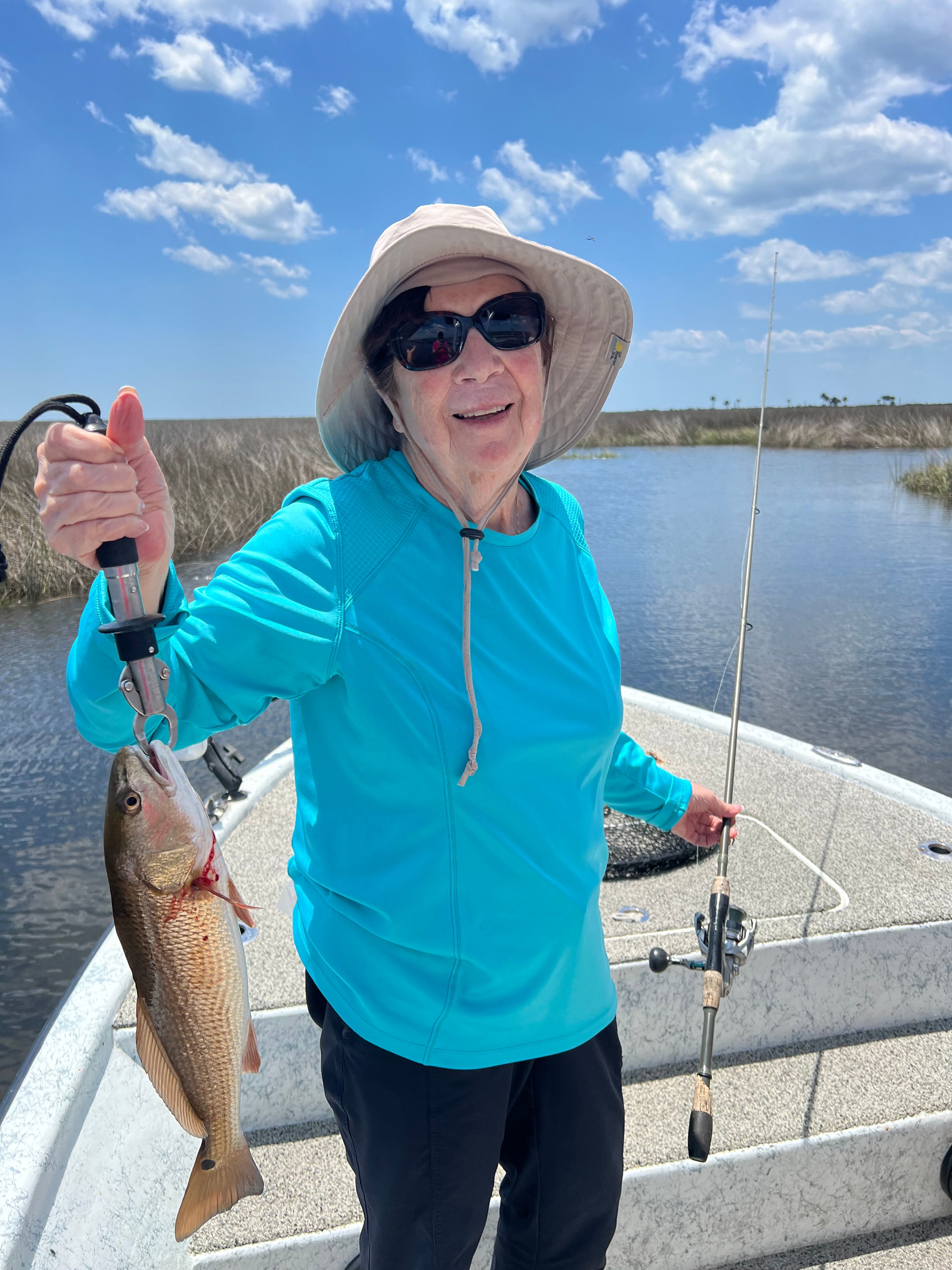 Angler holding freshly caught redfish on fishing boat