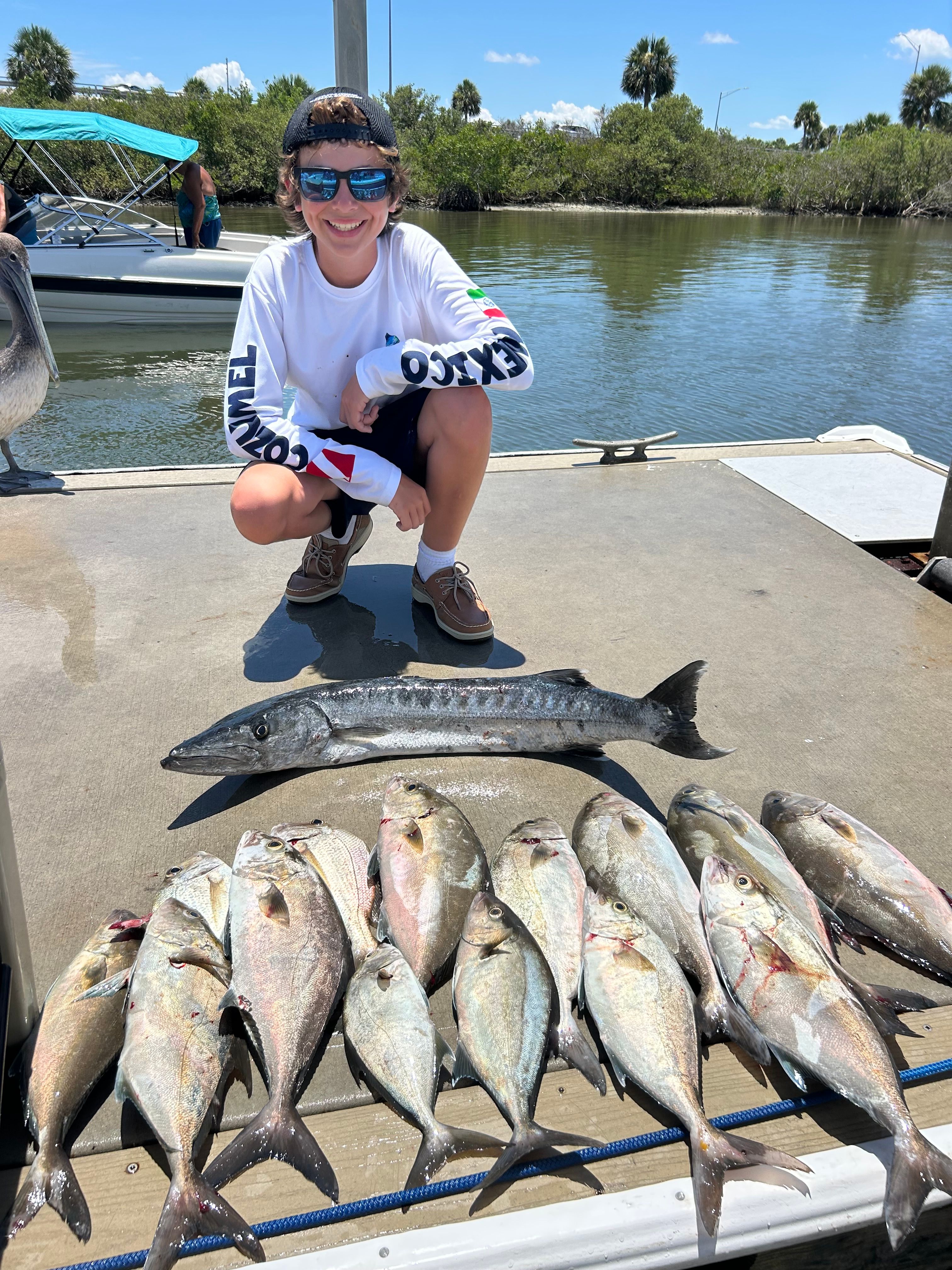 Fishing catch displayed on boat deck featuring Great Barracuda and Longfin Yellowtail