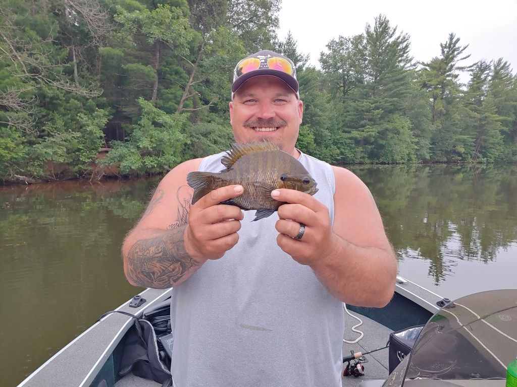 A person fishing with a rod and reel in an unknown location