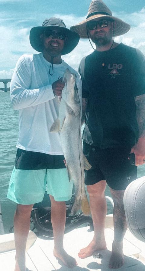 Snook fish caught by two people during a fishing trip