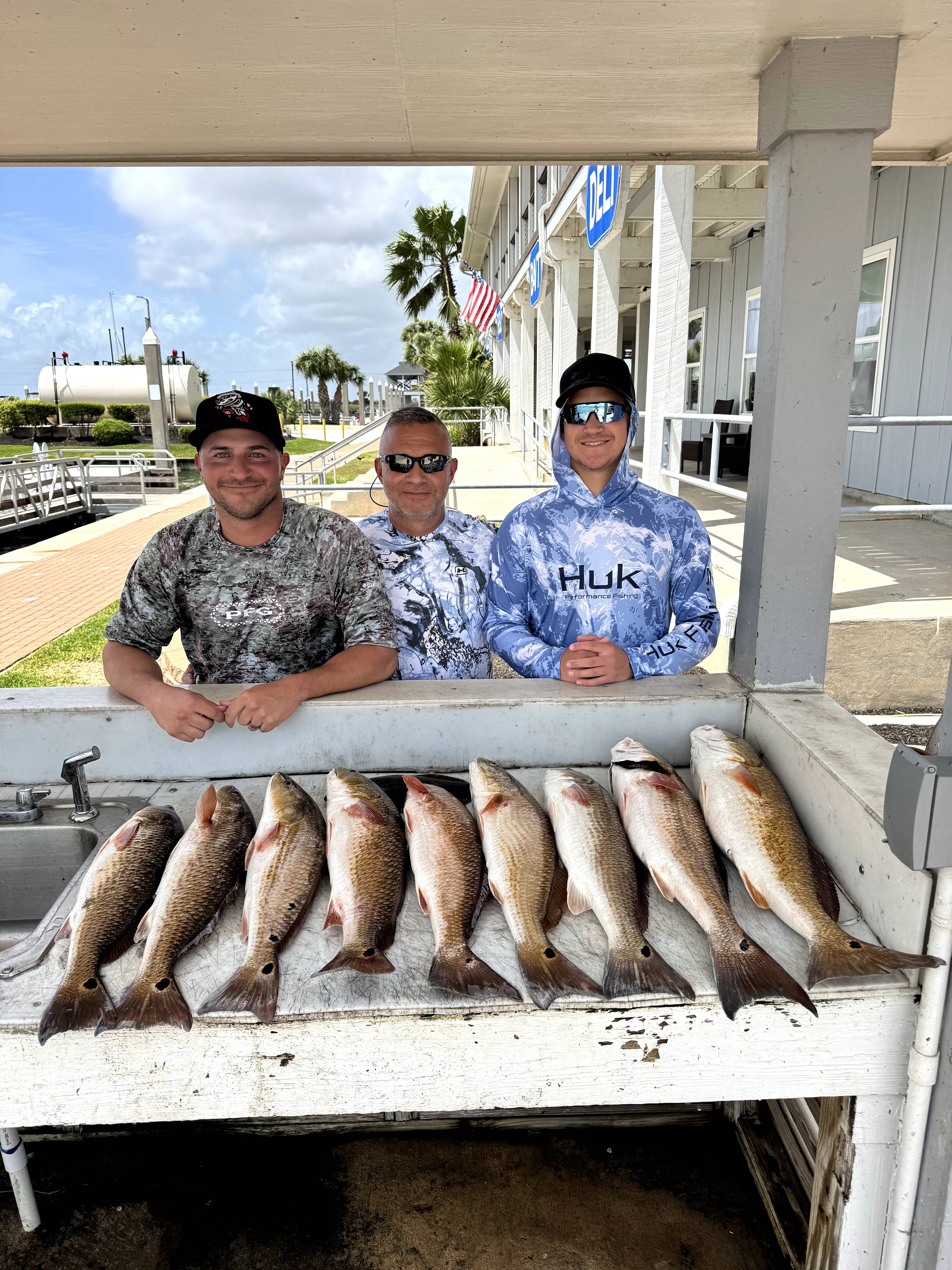 Seven redfish displayed on cleaning table at marina dock