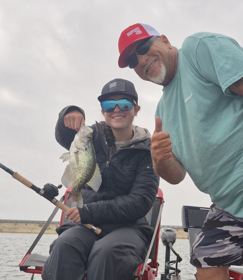 Freshly caught bass being held up on fishing boat