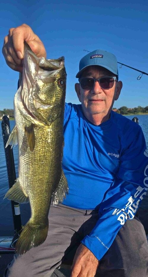 Angler holding freshly caught bass on fishing boat