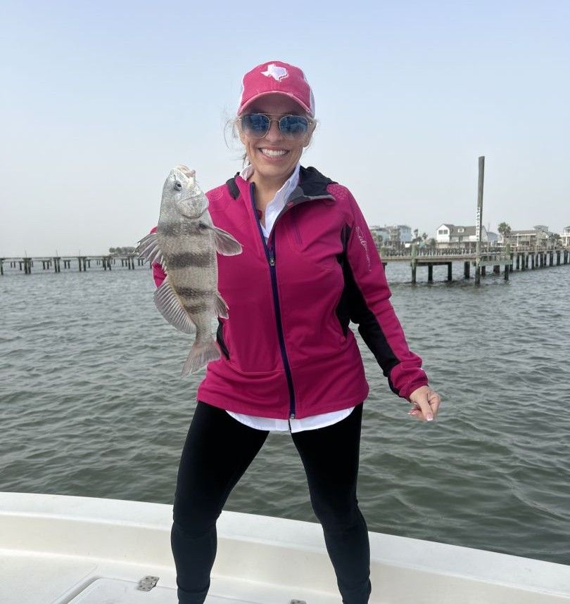 Angler holding freshly caught black drum fish on boat