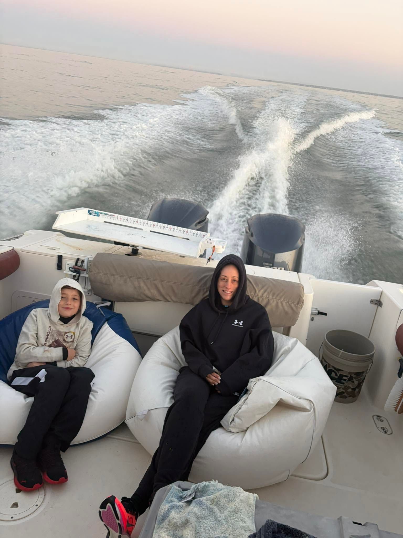 Boat wake churning white water behind moving vessel on calm ocean