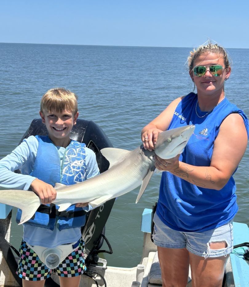 A bonnethead shark caught by two people fishing