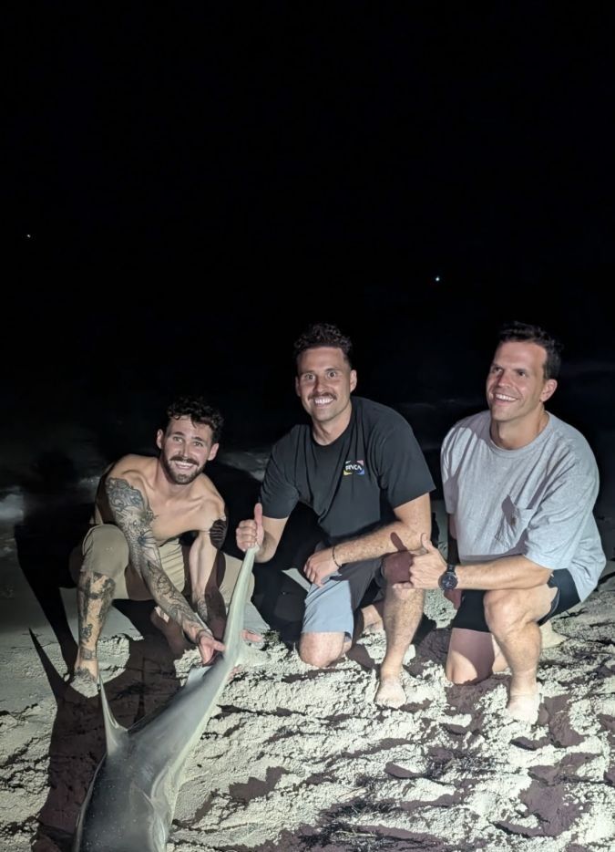 Three people fishing on a body of water