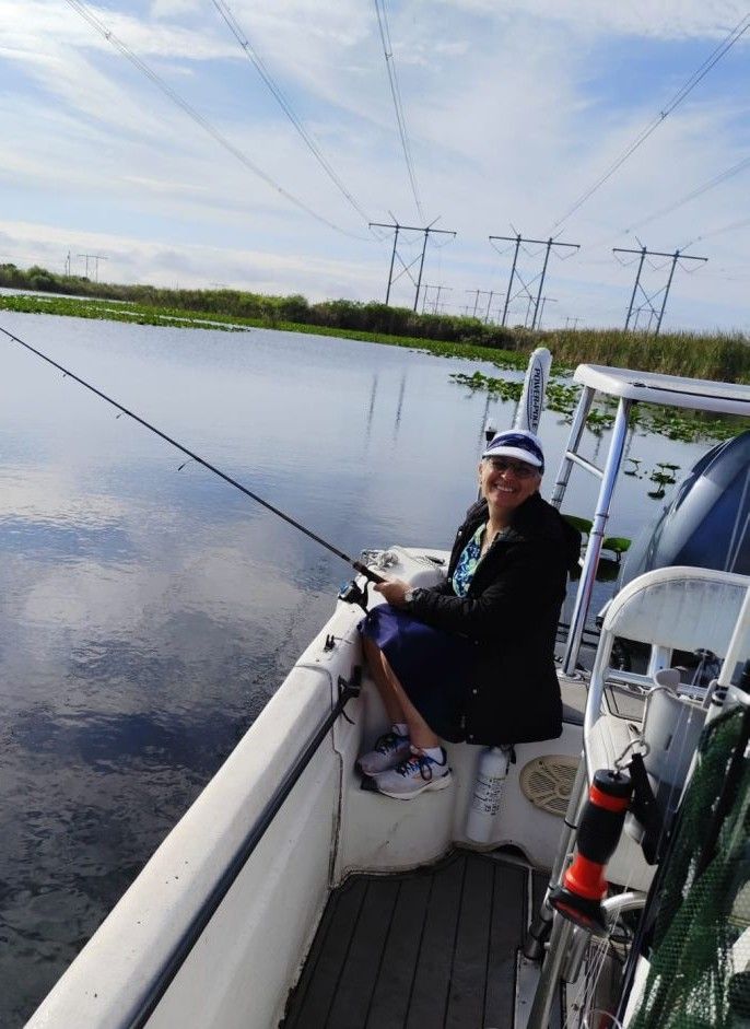 Fishing boat on calm water with power lines visible in background