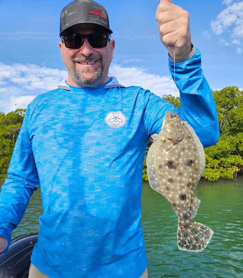 Angler holding freshly caught flatfish on fishing boat