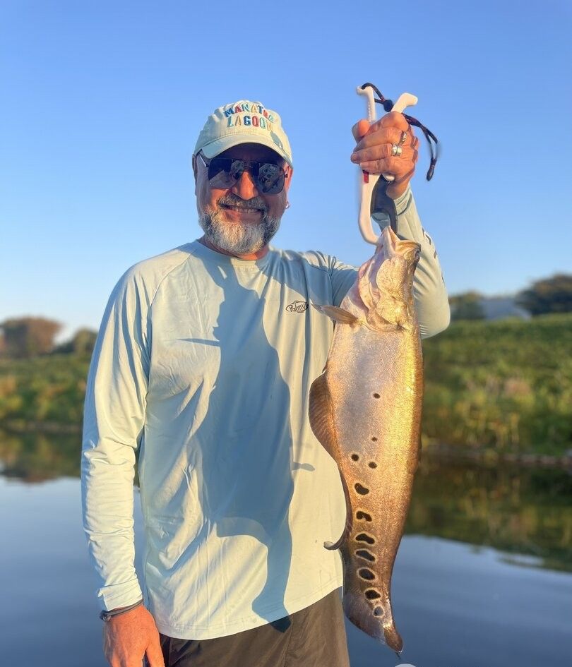 Angler holding freshly caught flatfish on fishing boat