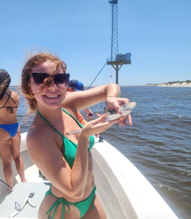 Fresh caught fish being held on fishing boat with water and tower structure in background